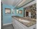 This remodeled bathroom offers a double sink vanity with granite counters, complemented by blue walls and stone accents at 523 Georgia Ave, Crystal Beach, FL 34681