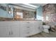 This bathroom features a double sink vanity with granite counters and a unique rock wall design at 523 Georgia Ave, Crystal Beach, FL 34681