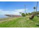 Scenic waterfront park featuring a wooden fishing pier, bench, and grassy lawn with Tampa Bay views at 523 Georgia Ave, Crystal Beach, FL 34681