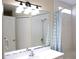 Well-lit bathroom featuring a vanity, mirror, and shower/tub with curtain at 5607 Tanagergrove Way, Lithia, FL 33547