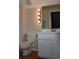 Well-lit bathroom features a white toilet, vanity, and a large mirror at 5607 Tanagergrove Way, Lithia, FL 33547