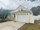 View of the house from the driveway showcasing the garage and landscaping at 5607 Tanagergrove Way, Lithia, FL 33547