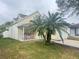 House exterior showcasing a well-maintained lawn and palm trees at 5607 Tanagergrove Way, Lithia, FL 33547