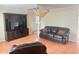 Living room with tiled floors, a brown leather couch, and a built-in entertainment center at 5607 Tanagergrove Way, Lithia, FL 33547