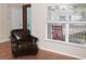 Living room showcasing tile floors, a large window with natural light, and a comfortable leather chair at 5607 Tanagergrove Way, Lithia, FL 33547