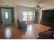 Living room with tiled floors, a brown leather sofa, and a large TV at 5607 Tanagergrove Way, Lithia, FL 33547