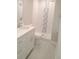 Updated bathroom with white vanity and mosaic tile shower at 5611 Riddle Rd, Holiday, FL 34690