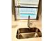 Close-up of kitchen sink with view to outdoor pool at 5611 Riddle Rd, Holiday, FL 34690