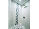 Walk-in shower featuring white subway tiles and a stylish mosaic accent at 5611 Riddle Rd, Holiday, FL 34690