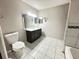 Bright bathroom featuring a toilet, shower-tub combo, vanity with ample storage, and tile flooring at 6441 Drexel Dr # 7, Port Richey, FL 34668