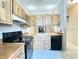 Kitchen featuring wood cabinets, black appliances, light countertops, and tile floors at 6441 Drexel Dr # 7, Port Richey, FL 34668