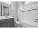 Modern bathroom with gray vanity, white tile, and bathtub at 6648 Sunset Vista Way, Land O Lakes, FL 34637