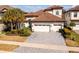 Two-story house with tile roof, three-car garage, and landscaped yard at 6648 Sunset Vista Way, Land O Lakes, FL 34637