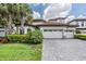 Two-story house with tile roof, three-car garage, and landscaped yard at 6648 Sunset Vista Way, Land O Lakes, FL 34637