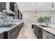 Modern kitchen with dark cabinetry, quartz countertops, and stainless steel appliances at 6648 Sunset Vista Way, Land O Lakes, FL 34637