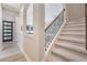 Elegant staircase with wrought iron railing and neutral wall colors at 6648 Sunset Vista Way, Land O Lakes, FL 34637