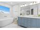 Elegant bathroom featuring a freestanding tub, dual vanity, and marble tile at 7810 10Th S Ave, St Petersburg, FL 33707