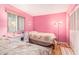 Pink bedroom featuring twin beds, a wicker desk, natural light, and closet with louvered doors at 801 83Rd N Ave # 217, St Petersburg, FL 33702