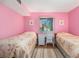 Bedroom featuring two twin beds, wood floors, and bright pink paint at 801 83Rd N Ave # 217, St Petersburg, FL 33702