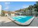 Bright swimming pool alongside a condo building featuring an awning and deck chairs at 801 83Rd N Ave # 217, St Petersburg, FL 33702