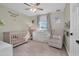 Bright Bedroom featuring a crib, dresser, and comfortable armchair at 8416 121St Pl, Largo, FL 33773