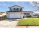 Two-story house with a white exterior, attached garage, and well-maintained lawn at 8416 121St Pl, Largo, FL 33773