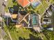 Aerial view of a home featuring a screened pool, boat dock, waterfront views, and lush landscaping at 952 Symphony Isles Blvd, Apollo Beach, FL 33572