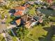 Aerial view of a home, showing a screened pool, dock, and boat lift, surrounded by lush landscaping at 952 Symphony Isles Blvd, Apollo Beach, FL 33572