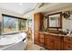 Bathroom featuring a large soaking tub, stained glass windows, and dual sink vanity at 952 Symphony Isles Blvd, Apollo Beach, FL 33572