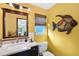 Yellow bathroom featuring a decorative fish on the wall, and a dark vanity with a stone countertop at 952 Symphony Isles Blvd, Apollo Beach, FL 33572