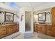 Bathroom with double sinks, wooden cabinets, granite counters and shower at 952 Symphony Isles Blvd, Apollo Beach, FL 33572