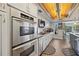 Well-equipped kitchen featuring stainless steel appliances, custom cabinetry, and stylish wood flooring at 952 Symphony Isles Blvd, Apollo Beach, FL 33572