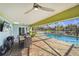 View from a covered patio to a screened pool with a canal in the background and outdoor furniture on the patio at 952 Symphony Isles Blvd, Apollo Beach, FL 33572