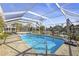 Screened pool with a waterfront view featuring a clear blue pool, patio furniture, and palm trees in the distance at 952 Symphony Isles Blvd, Apollo Beach, FL 33572