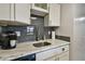 Modern kitchen with gray backsplash and marble countertops at 9715 Harrell Ave # 25, Treasure Island, FL 33706