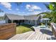 Backyard view showing wood deck, screened in lanai, lush landscaping and comfortable seating area perfect for relaxing at 9942 56Th Way, Pinellas Park, FL 33782