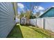 Side yard featuring lush green grass, white vinyl fence, and useful garden shed at 9942 56Th Way, Pinellas Park, FL 33782