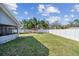 Large backyard space with a covered lanai, spacious deck, beautiful palms, and white vinyl fence at 9942 56Th Way, Pinellas Park, FL 33782