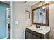 The powder room features a wooden vanity with a white sink, a large mirror, and unique lighting at 9942 56Th Way, Pinellas Park, FL 33782