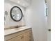 The bathroom features a vanity, round mirror, and a natural light from the window at 9942 56Th Way, Pinellas Park, FL 33782