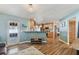 A view into the kitchen from a cozy living room showcasing warm wood floors and ample natural light at 9942 56Th Way, Pinellas Park, FL 33782