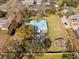 Property featuring a home with a blue metal roof, mature trees, tennis court, and spacious lawns within clearly marked boundaries at 13050 110Th Ave, Largo, FL 33774