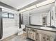 Bathroom featuring a wood vanity cabinet, tub with shower, and decorative gray stone wall at 13050 110Th Ave, Largo, FL 33774