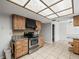 Well-lit kitchen featuring a stainless steel stove, wood cabinets, and neutral tile flooring at 13050 110Th Ave, Largo, FL 33774