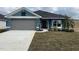 Newly constructed home with gray garage door and blue exterior at 13146 Kent Bradley St, Dade City, FL 33525