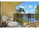 Charming balcony with white wicker chairs and a table, overlooking a tranquil lake and scenic landscape at 1450 Heather Ridge Blvd # 305, Dunedin, FL 34698