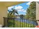 Relaxing balcony view overlooking a serene lake, lush greenery and blue skies, with a glimpse of a neighborhood at 1450 Heather Ridge Blvd # 305, Dunedin, FL 34698