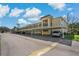 Exterior view of building featuring carports, well-maintained grounds, and ample parking for residents and visitors at 1450 Heather Ridge Blvd # 305, Dunedin, FL 34698