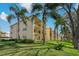 Multi-story building with balconies, set amidst lush green lawns and palm trees offering residents scenic outdoor living at 1450 Heather Ridge Blvd # 305, Dunedin, FL 34698