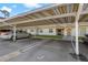 Assigned carport parking spot beneath a building, surrounded by well-maintained landscaping and building access at 1450 Heather Ridge Blvd # 305, Dunedin, FL 34698